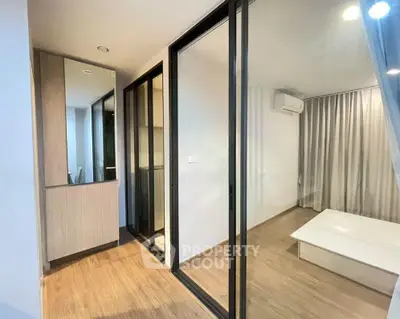 Modern apartment interior with sliding glass doors and wooden flooring