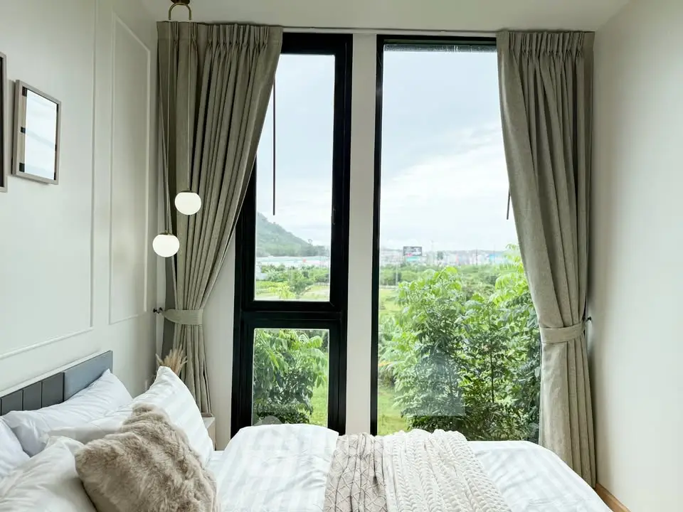 Cozy bedroom with large windows offering a stunning garden view