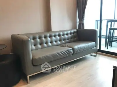 Modern living room with sleek leather sofa and balcony view, perfect for urban living.