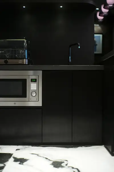 Modern kitchen with sleek black cabinetry and built-in microwave