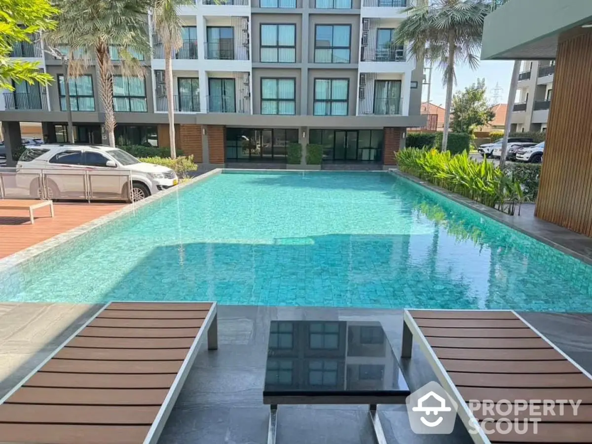 Luxurious apartment complex with inviting swimming pool and modern design.