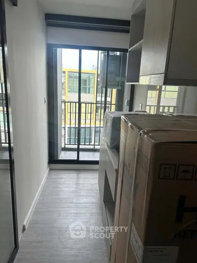 Compact apartment interior with balcony view and modern appliances
