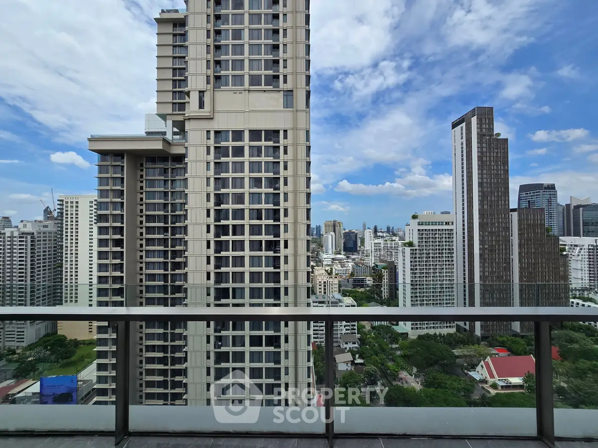 Stunning cityscape view from a high-rise balcony showcasing modern skyscrapers and blue sky.