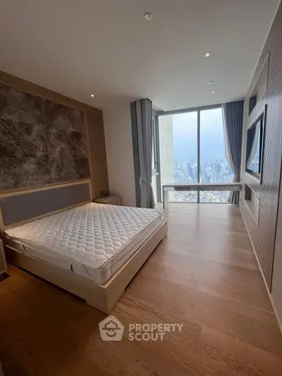 Luxurious bedroom with stunning city view from floor-to-ceiling windows, featuring modern decor and elegant design.