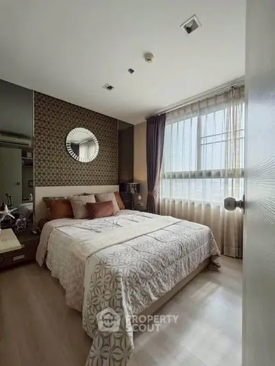 Cozy bedroom with modern decor and large window for natural light