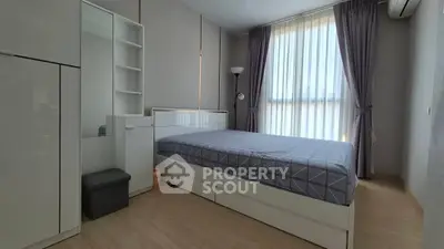 Modern bedroom with sleek furniture and large window with curtains