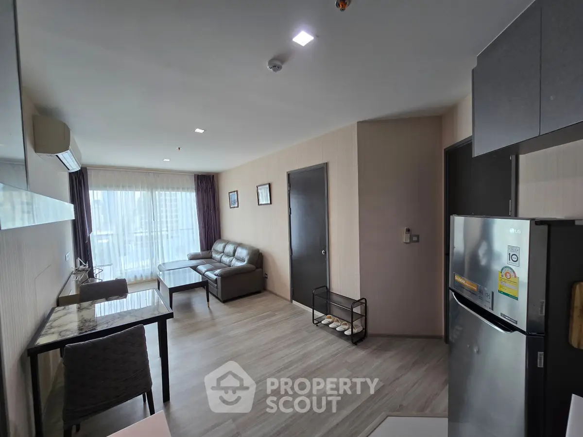 Modern living room with sleek furniture and open layout, featuring a cozy sofa and dining area.