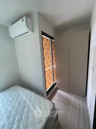Cozy bedroom with air conditioning and wardrobe, perfect for comfortable living.