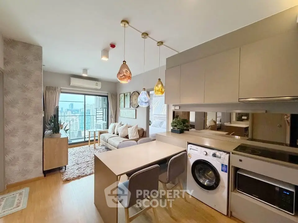 Modern open-plan living room with stylish kitchen and cozy seating area, featuring large windows and chic lighting.