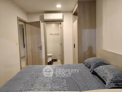 Cozy bedroom with modern design and ensuite bathroom, featuring built-in wardrobe and air conditioning.