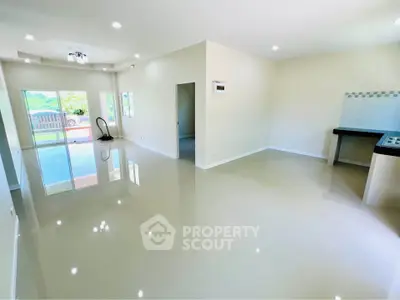 Spacious open-plan living area with glossy floors and large windows for natural light.
