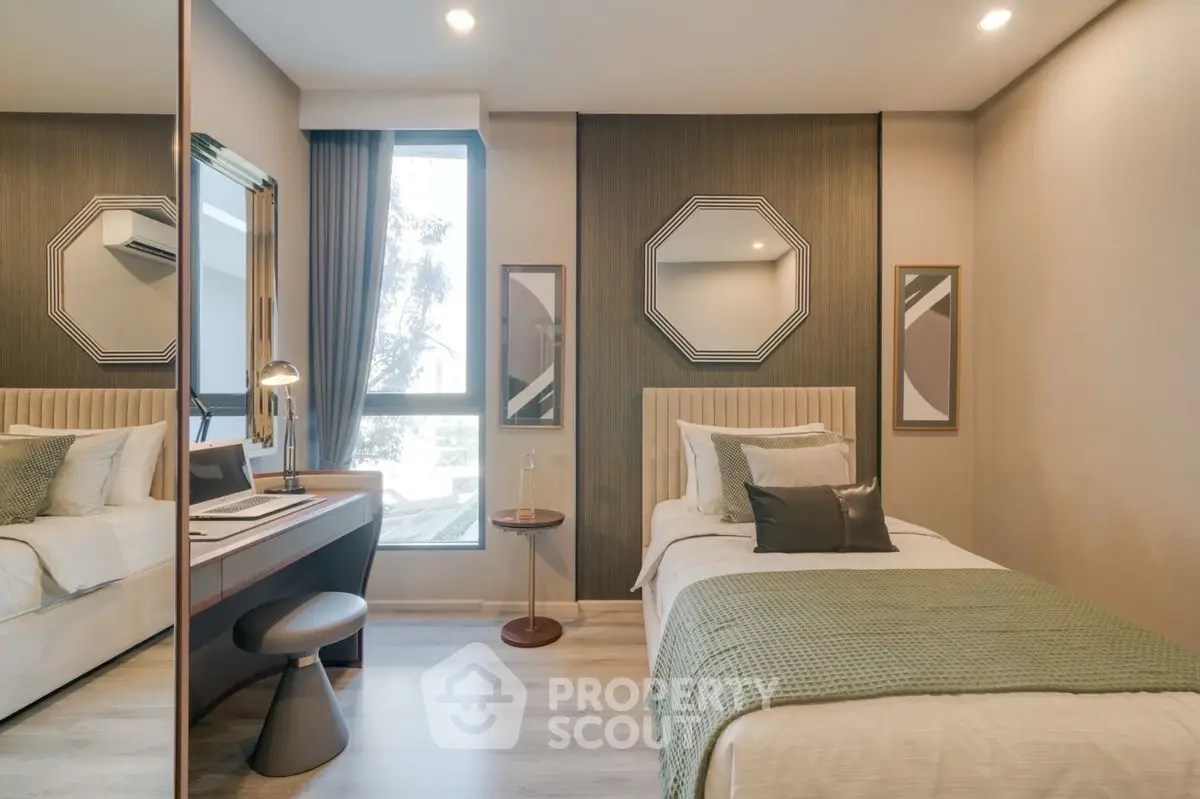 Modern bedroom with stylish decor and natural light, featuring a cozy single bed and workspace.