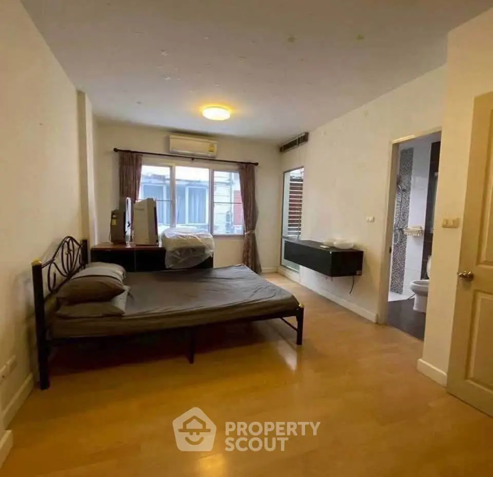 Spacious bedroom with ensuite bathroom and modern furnishings in a cozy apartment.