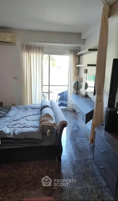Spacious bedroom with modern decor and natural light, featuring a cozy bed and stylish shelving.