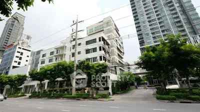 Modern urban apartment buildings with lush greenery and street view