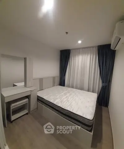 Cozy bedroom with modern furnishings and natural light, featuring a comfortable bed and stylish curtains.