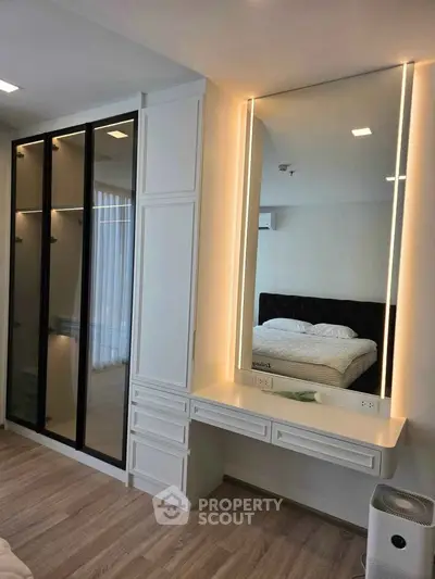 Modern bedroom with elegant vanity and spacious wardrobe in a stylish apartment.