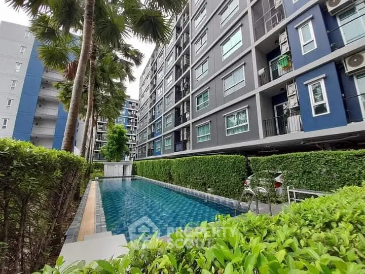 Modern condominium with pool and lush greenery, perfect for urban living.