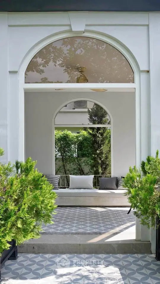 Elegant garden entrance with stylish archway and lush greenery