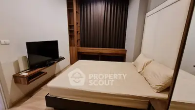 Modern bedroom with sleek design, featuring a comfortable bed and wall-mounted TV, ideal for urban living.