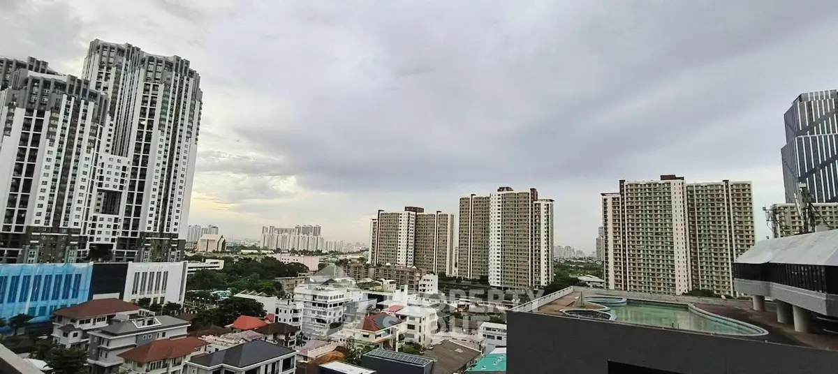 Stunning cityscape view with modern high-rise buildings and a rooftop pool, perfect for urban living.