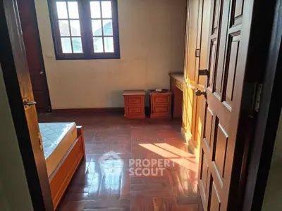 Cozy bedroom with wooden flooring and ample natural light