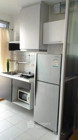 Modern compact kitchen with sleek appliances and ample storage in a stylish apartment.