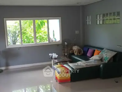 Spacious living room with large window and cozy seating area