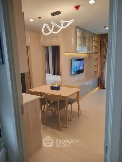 Modern apartment interior with stylish dining area and built-in TV unit, showcasing elegant lighting and cozy ambiance.