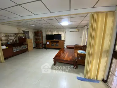 Spacious living room with wooden furniture and ample natural light