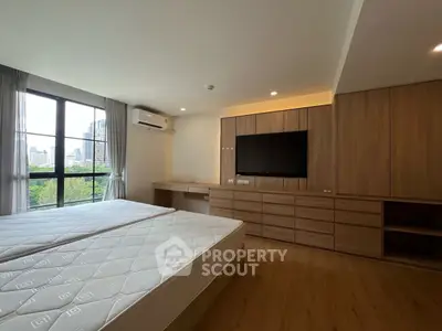 Spacious modern bedroom with city view and built-in wooden furniture