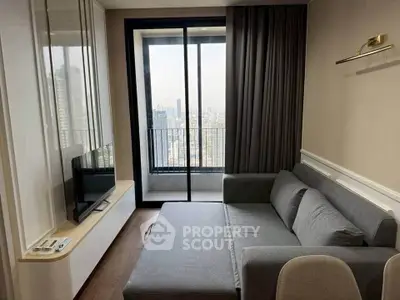 Modern living room with gray sofa and city view balcony in high-rise apartment.