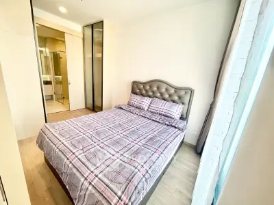 Modern bedroom with stylish decor and ensuite bathroom in a bright apartment.