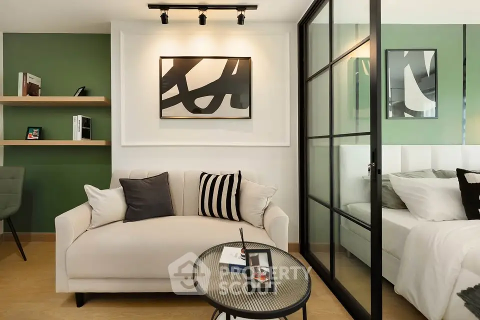 Modern living room with stylish decor and glass partition leading to bedroom