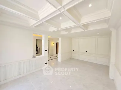 Spacious and elegant living room with coffered ceiling and marble flooring