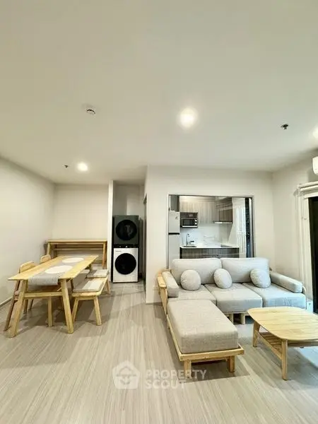 Modern living room with cozy seating and dining area, open kitchen layout, and in-unit laundry.