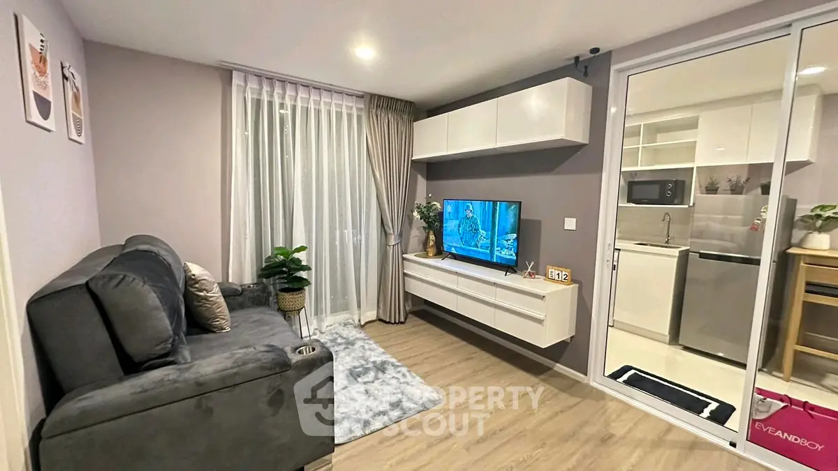 Modern living room with sleek furniture and open kitchen view.