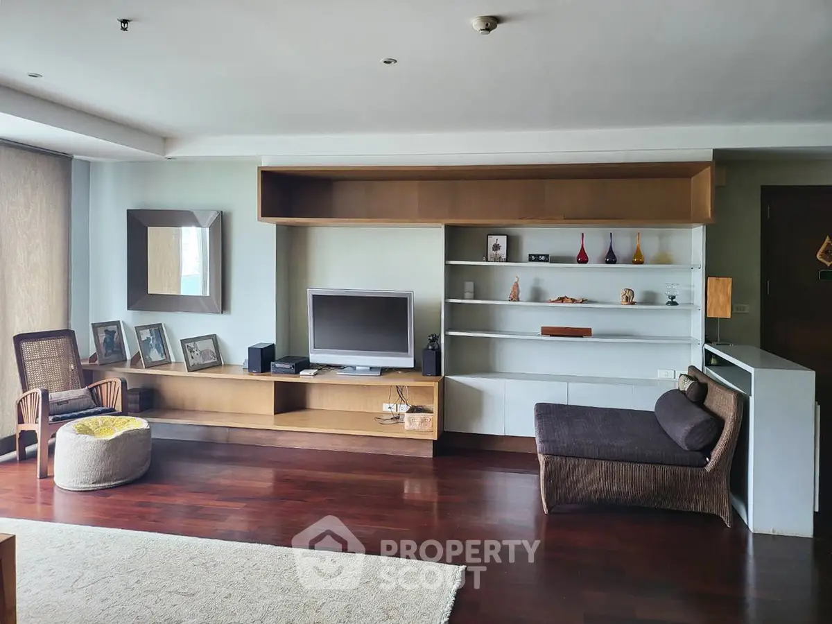 Spacious living room with modern decor and hardwood floors in a stylish apartment.