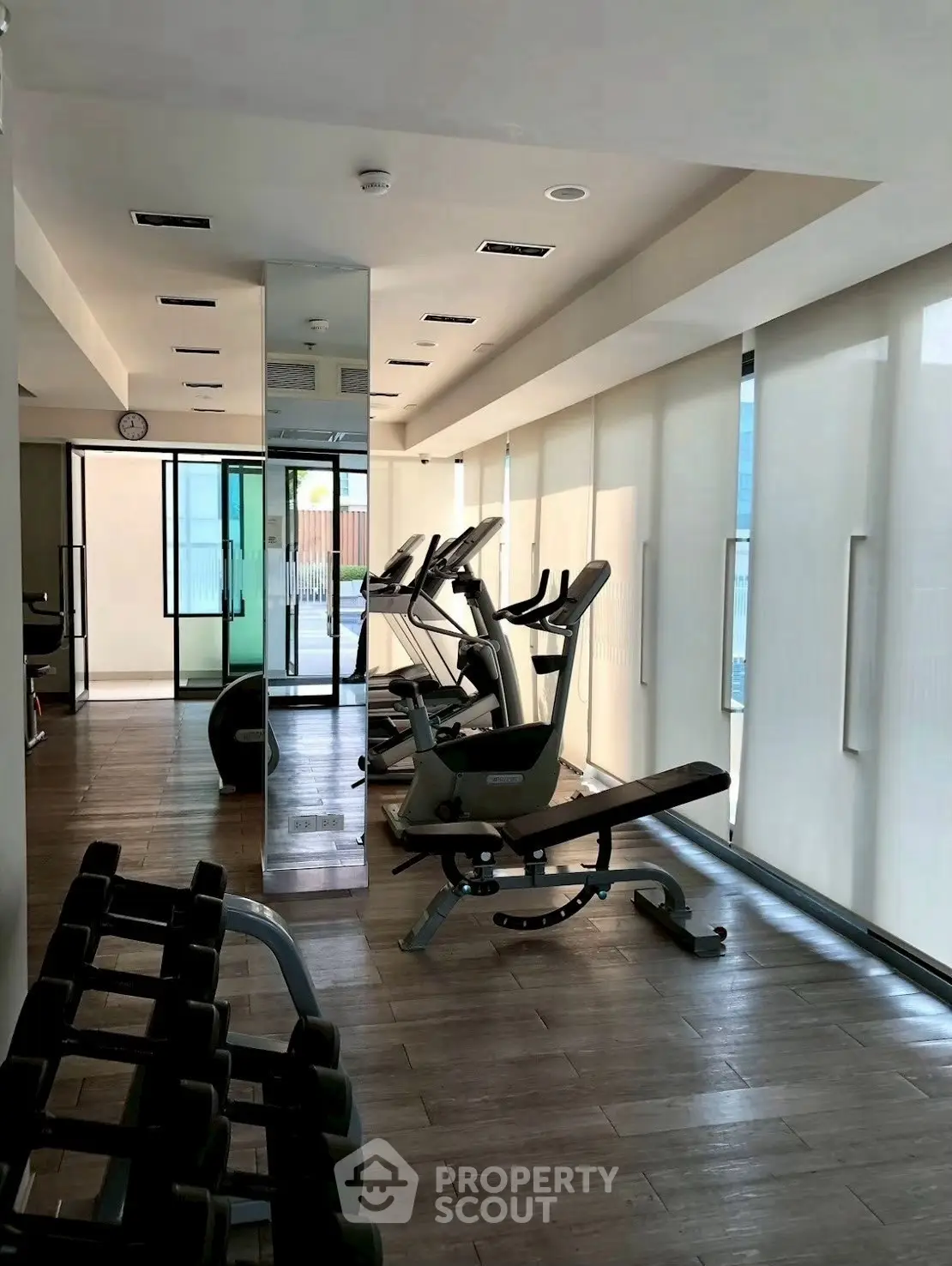 Modern gym with exercise equipment and natural lighting in a residential building.