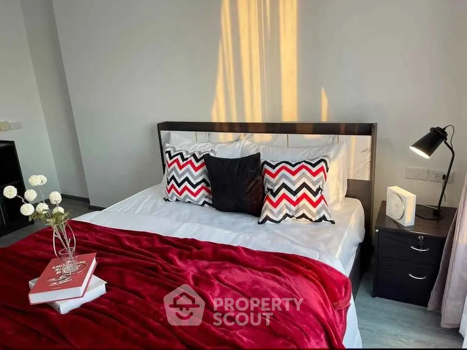 Modern bedroom with stylish decor and cozy red blanket