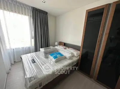 Modern bedroom with large window and sleek wardrobe in a stylish apartment.