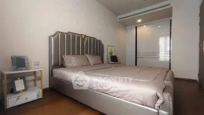 Luxurious bedroom with elegant decor and plush bedding in modern apartment.