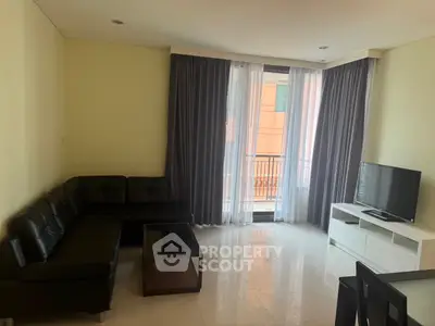 Spacious living room with modern furniture and balcony access