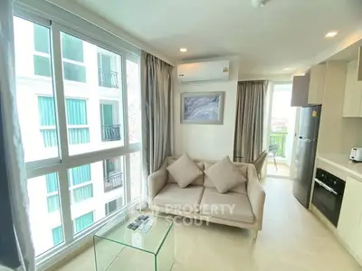 Modern living room with large windows and stylish furniture in a high-rise apartment.