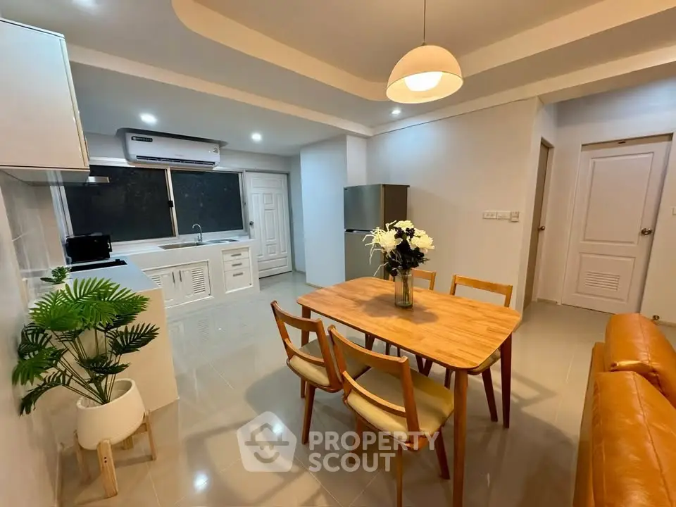 Modern open-layout kitchen and dining area with stylish furniture and bright lighting.
