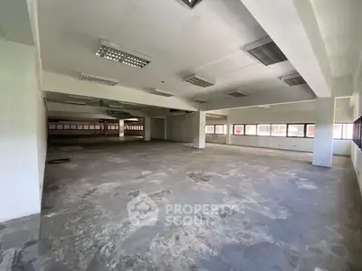 Spacious open-plan commercial space with large windows and ample natural light.