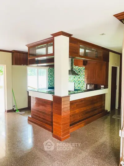 Charming kitchen with wooden cabinetry and colorful backsplash in a cozy home setting.