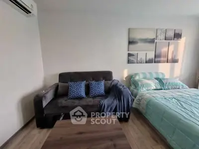 Cozy bedroom with stylish decor and comfortable seating area.