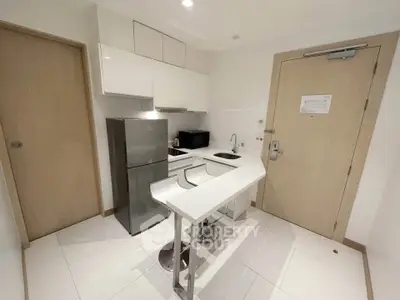 Modern compact kitchen with sleek appliances and breakfast bar in a stylish apartment.