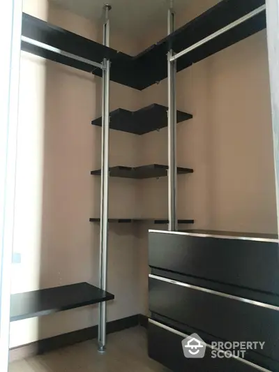 Spacious walk-in closet with custom shelving and modern design, perfect for organizing a large wardrobe and accessories.